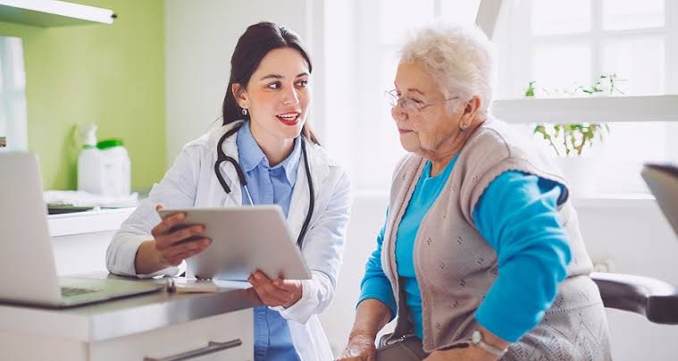 A doctor going over plan details on a tablet with an older patient.